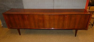une commode en bois surmontée d'un miroir