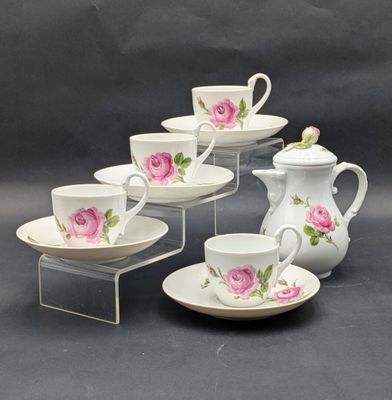 five cups and a saucer with a rose design on them