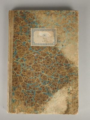 an old book with a blue and brown cover sitting on a table