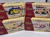 four boxed boxes of toy vehicles are sitting on a white surface