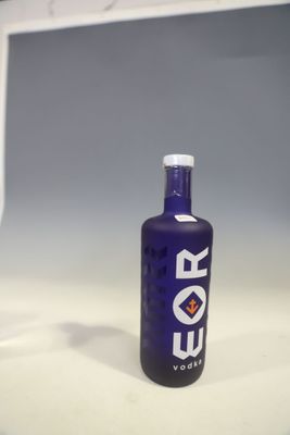 a bottle of vodka sitting on a counter next to a glass of wine