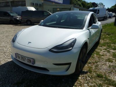 une Tesla Model 3 blanche garée sur un parking