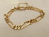 a close up of a gold chain bracelet on a white surface