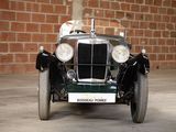 a vintage car that is parked in front of a brick wall