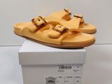 yellow leather sandals with buckles are on top of a white box