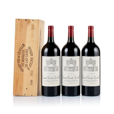 three bottles of red wine and a wooden box on a white surface