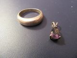 une bague en argent et une pierre rose posées sur une table