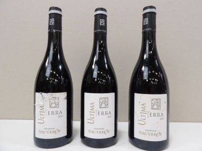 trois bouteilles de vin posées sur une table, l'une à côté de l'autre