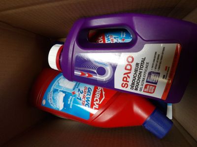 two bottles of toothpaste in a cardboard box on a table