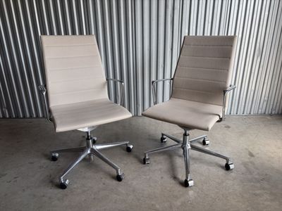 deux chaises de bureau placées côte à côte devant un mur en tôle ondulée