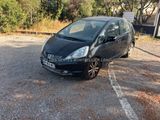 a black car parked in a parking lot next to trees