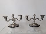 pair of silver plated candlesticks on a clear glass table