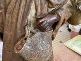 a statue of a man holding a basket in his hand