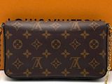 a louis vuitton wallet bag with a chain around it