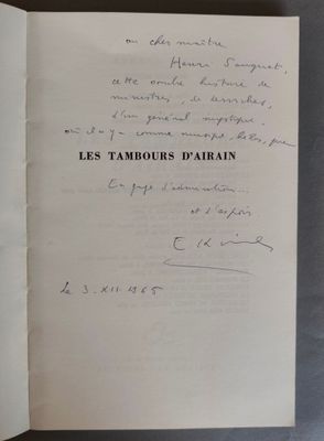 un livre ouvert, sur lequel est inscrit un poème écrit à la main, posé sur une table