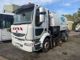 un camion blanc garé à côté d'un bus