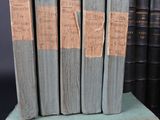 several old books are stacked on top of each other on a table