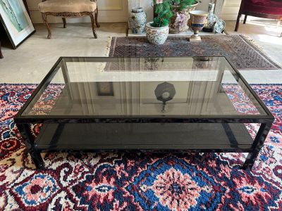 une table basse avec un plateau en verre posée sur un tapis dans un salon