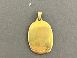 a gold plated pendant with a small disc on it