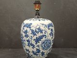 blue and white vase with a light bulb on top of it