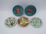 trois petites assiettes ornées de motifs floraux, posées sur une surface blanche