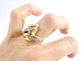 a person ' s hand holding a gold and diamond ring