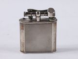 a silver lighter that is sitting on a white surface