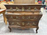 une commode ancienne surmontée de ferrures en laiton