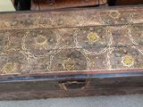 an old wooden chest sitting on the floor next to a chair