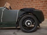 a vintage car parked in front of a brick wall