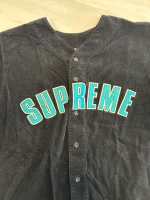 a close up of a baseball jersey with the word supreme on it