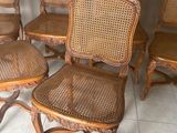 six chaises anciennes à dossier en rotin alignées sur un sol carrelé