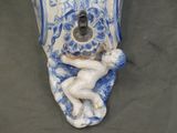 a blue and white vase with a statue on it