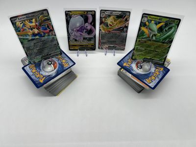 quatre cartes Pokémon empilées les unes sur les autres sur une table