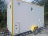 a small white and yellow portable toilet on a trailer