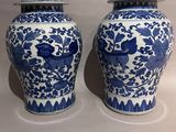 two blue and white vases with lids on a white surface