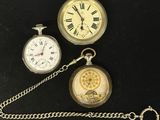 trois types différents de montres de poche attachées à une chaîne, posées sur un fond noir