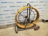 a cart with a hose on it in front of a wall