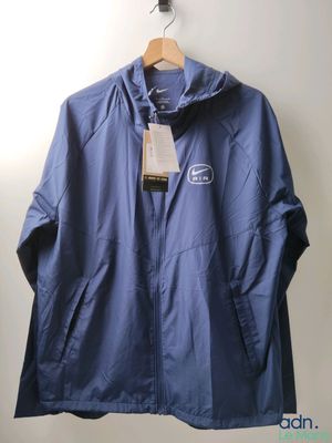 blue jacket hanging on a hanger on a wall with a tag on it
