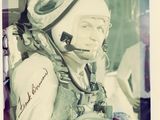 une vieille photo d'un homme en combinaison spatiale, assis sur une chaise