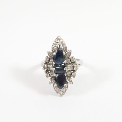 a close up of a blue sapphire and diamond ring on a white background