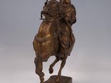statue of a man riding a horse on a wooden base