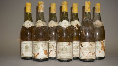 six bouteilles de vin sont alignées sur une table