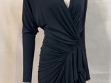 the dress is black and has long sleeves and a v - neck