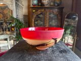 a red bowl sitting on top of a wooden table