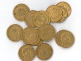 une pile de pièces d'or posée sur une surface blanche