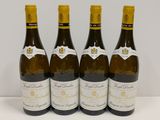 quatre bouteilles de vin sont alignées sur une table