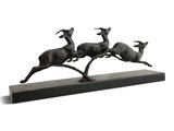 bronze sculpture of three running deers on a black base