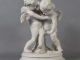a statue of two children hugging each other on a pedestal