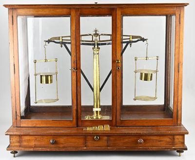 une vieille vitrine en bois surmontée d'une balance